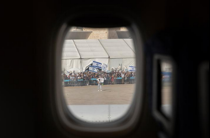 A celebratory crowd gathers on the tarmac of Tel Aviv's Ben Gurion Airport to welcome new Jewish immigrants.