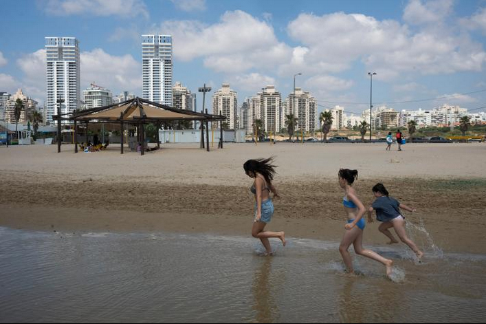 Oria Vidal, an Israeli native whose parents immigrated from France 20 years ago, plays on the beach in Netanya with her cousins Eden and Lena, who are visiting from Strasbourg, France. Netanya, a coastal city north of Tel Aviv, is home to a large community of French immigrants. Photograph by William Daniels