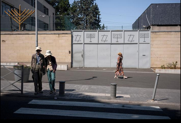 A closed metal gate marks the entrance to the Great Synagogue of Sarcelles in France.