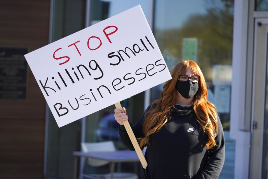 Lisa Kreyer holds up a sign during a protest by hair salon owners and workers against lockdown orders in 2020, in San Rafael, Calif. A study has concluded that lockdowns “are ill-founded and should be rejected as a pandemic policy instrument.” Eric Risberg / AP