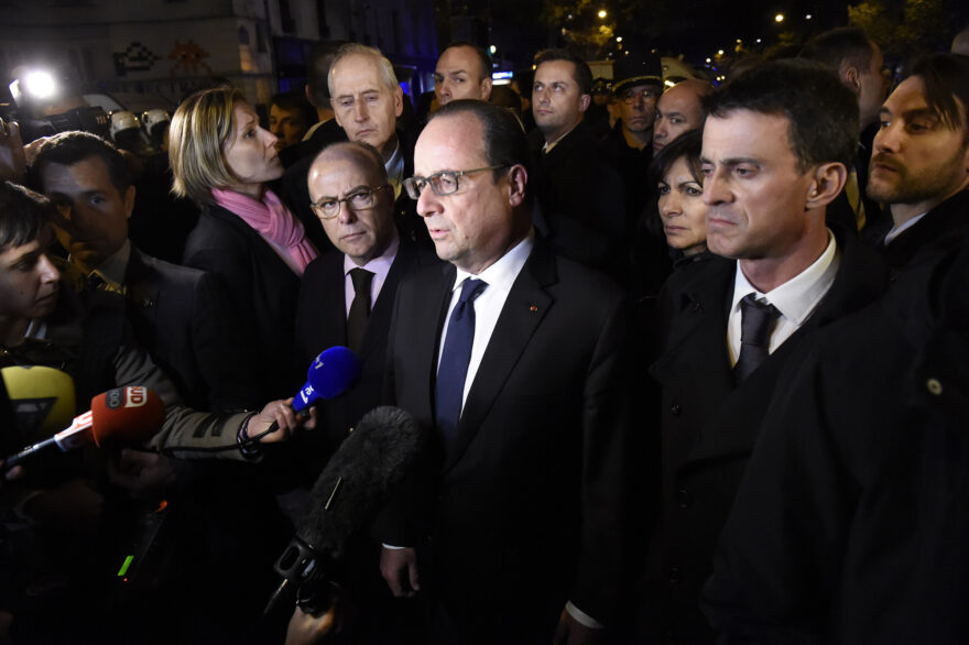 French President Francois Hollande (C), flanked by French Interior Minister Bernard Cazeneuve (L) and French Prime Minister manuel Valls (R) addresses reporters near the Bataclan concert hall in central Paris, early on November 14, 2015. A number of people were killed in an "unprecedented" series of bombings and shootings across Paris and at the Stade de France stadium on November 13, and the death toll looked likely to rise as sources said dozens had been killed at the Bataclan popular music venue. AFP PHOTO / MIGUEL MEDINA (Photo credit should read MIGUEL MEDINA/AFP/Getty Images)