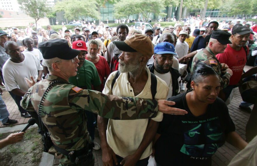 A Louisiana National Guardsmen holds back residents as they gather outside the Louisiana Superdome in New Orleans on Sunday, Aug. 28, 2005. The Superdome opened Sunday to residents of New Orleans who are seeking shelter from Hurricane Katrina which is expected to make landfall on Monday. (AP Photo/Dave Martin)