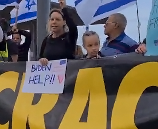 leftists gathered outside U.S. consulate in Tel Aviv holding up signs Biden help!