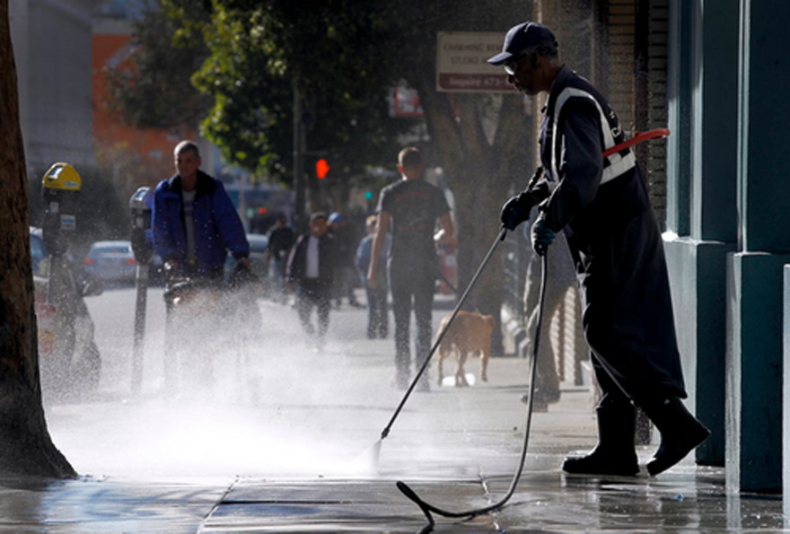 A Clean City team in the Tenderloin power washes the sidewalk on Hyde Street in San Francisco. | Paul Chinn/The San Francisco Chronicle via Getty Images
