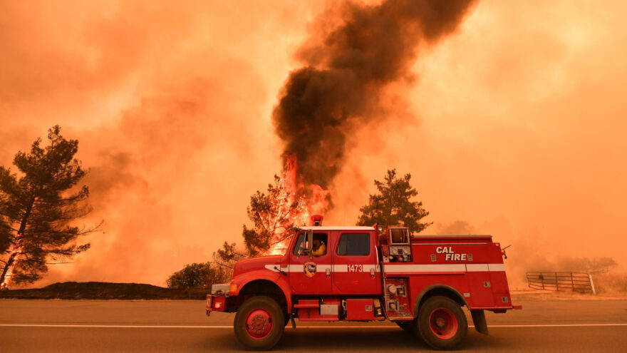 Firefighters work to control a fire as flames from the County Fire jump across Highway 20 near Clearlake Oaks, California, on July 1. Credit: JOSH EDELSON/AFP/Getty Images