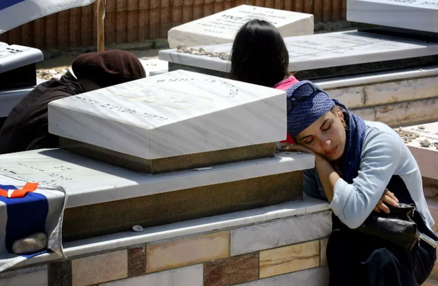 DAVID FURST / AFP - An Israeli mourns over the grave of a relative for last time prior to the uprooting of graves as part of Israel's ongoing disengagement plan, at the Gush Katif cemetery near the southern Gaza Strip settlement of Newe Dekalim August 23, 2005