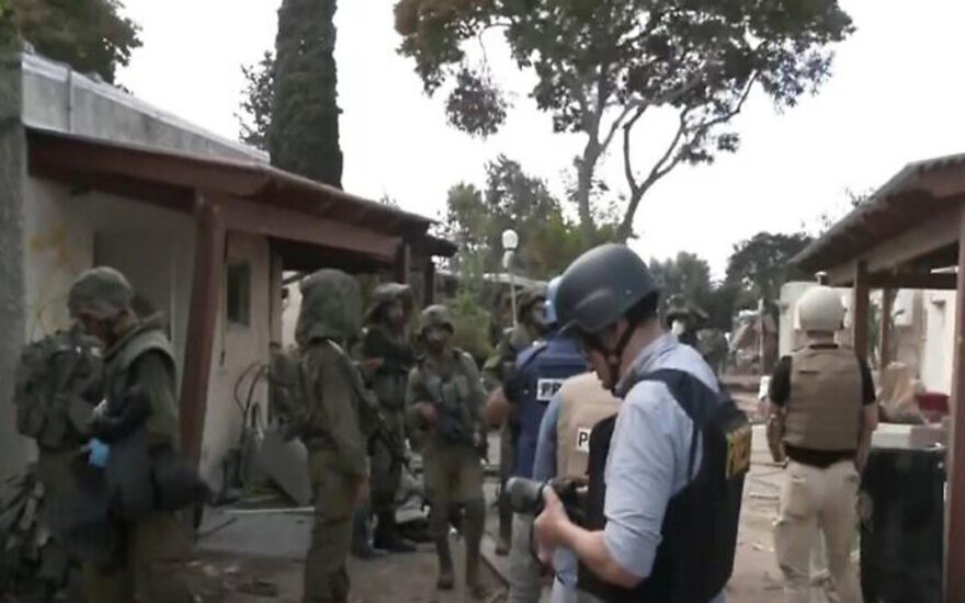 IDF soldiers on October 10, 2023, show members of the foreign press around Kibbutz Kfar Aza, one of the southern Israeli communities where Hamas terrorists massacred hundreds of Israeli civilians on October 7, 2023 (Channel 12 screenshot used in accordance with clause 27a of the Copyright Law)