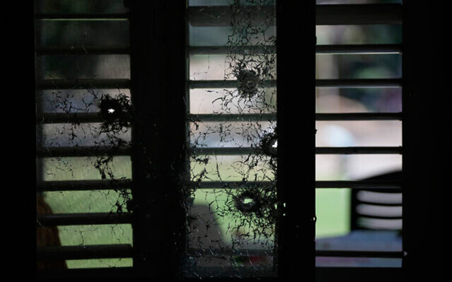 The bullet-shattered window of a house at Kibbutz Kfar Aza on October 10, 2023. (AP Photo/Ohad Zwigenberg)
