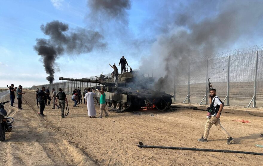 Hamas troops burn an Israeli tank on October 7, 2023. Photo credit: IMAGO/APAimages via Reuters Connect.