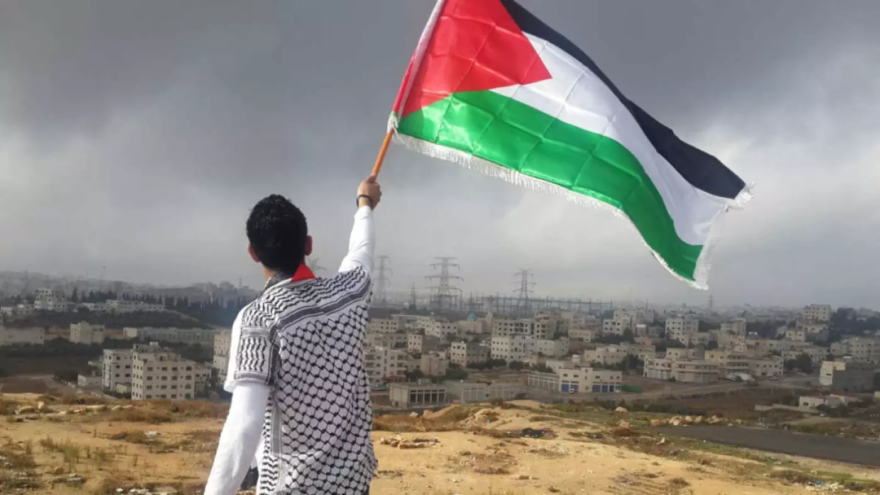 The photo of a man waving a Palestinian flag that was shared on the Facebook page of a senior CIA official (Photo by Ahmed Abu Hameeda/Unsplash) 