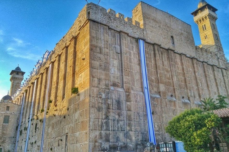 Israel flags decorate the 2,000-year-old Cave of the Patriarchs complex in Hebron in anticipation of Independence Day, May 2018. The same Herodian masonry is used for the Western Wall in Jerusalem. Photo by Yishai Fleisher
