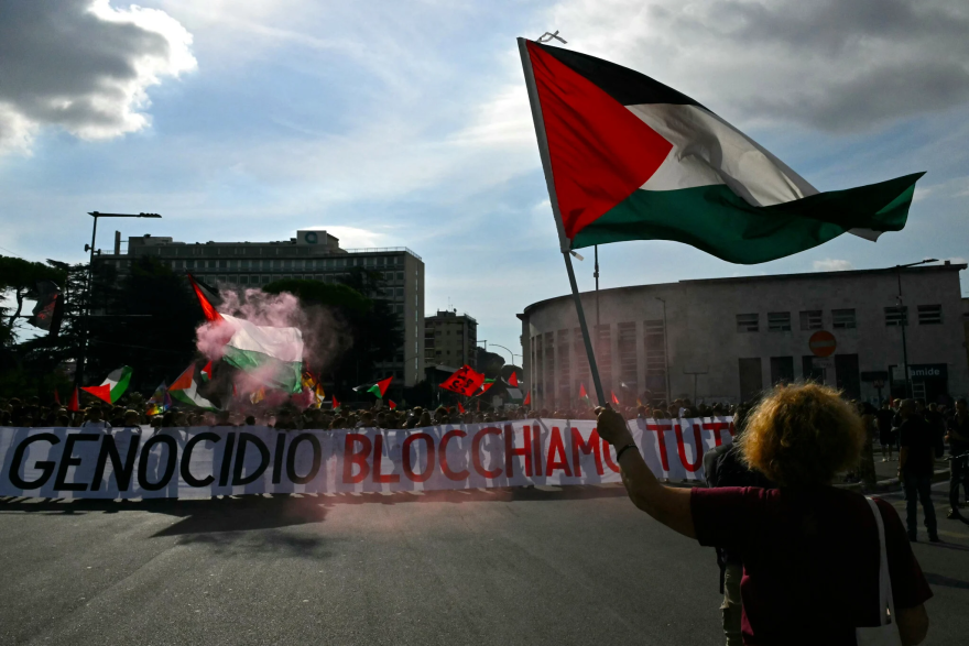 People march behind a banner reading “Against Genocide Let’s block everything” during a nationwide strike in solidarity with Palestinians in Gaza and calling for a halt to arms shipments to Israel, in Rome on September 22, 2025. (Andreas SOLARO / AFP)